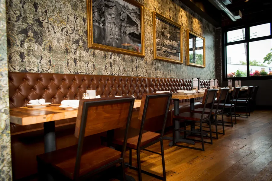 Long dining room with banquette seating under framed photographs