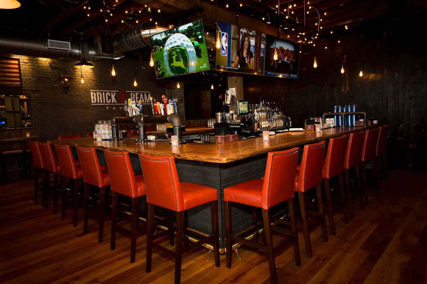 The bar at Brick & Beam Tavern with orange leather stools
