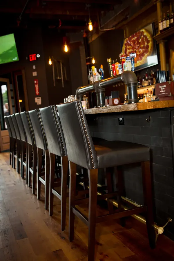 The bar with grey leather stools and taps