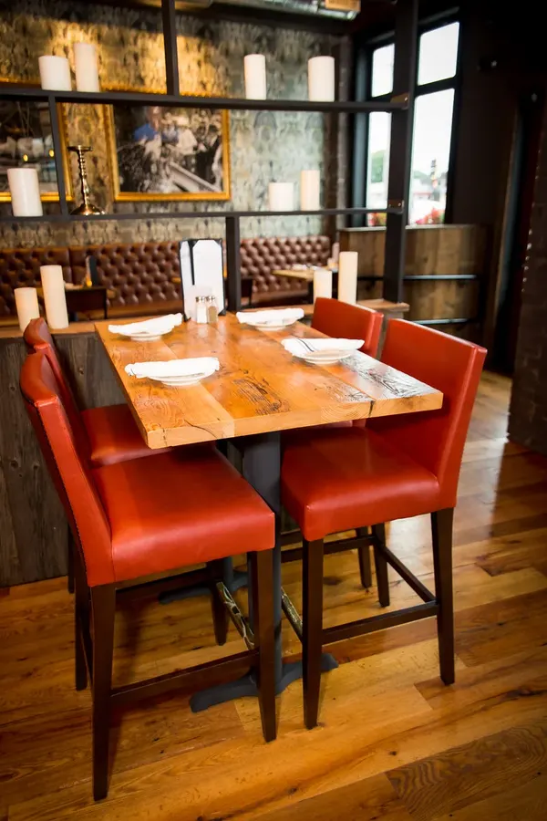 Wood table with orange chairs by the window