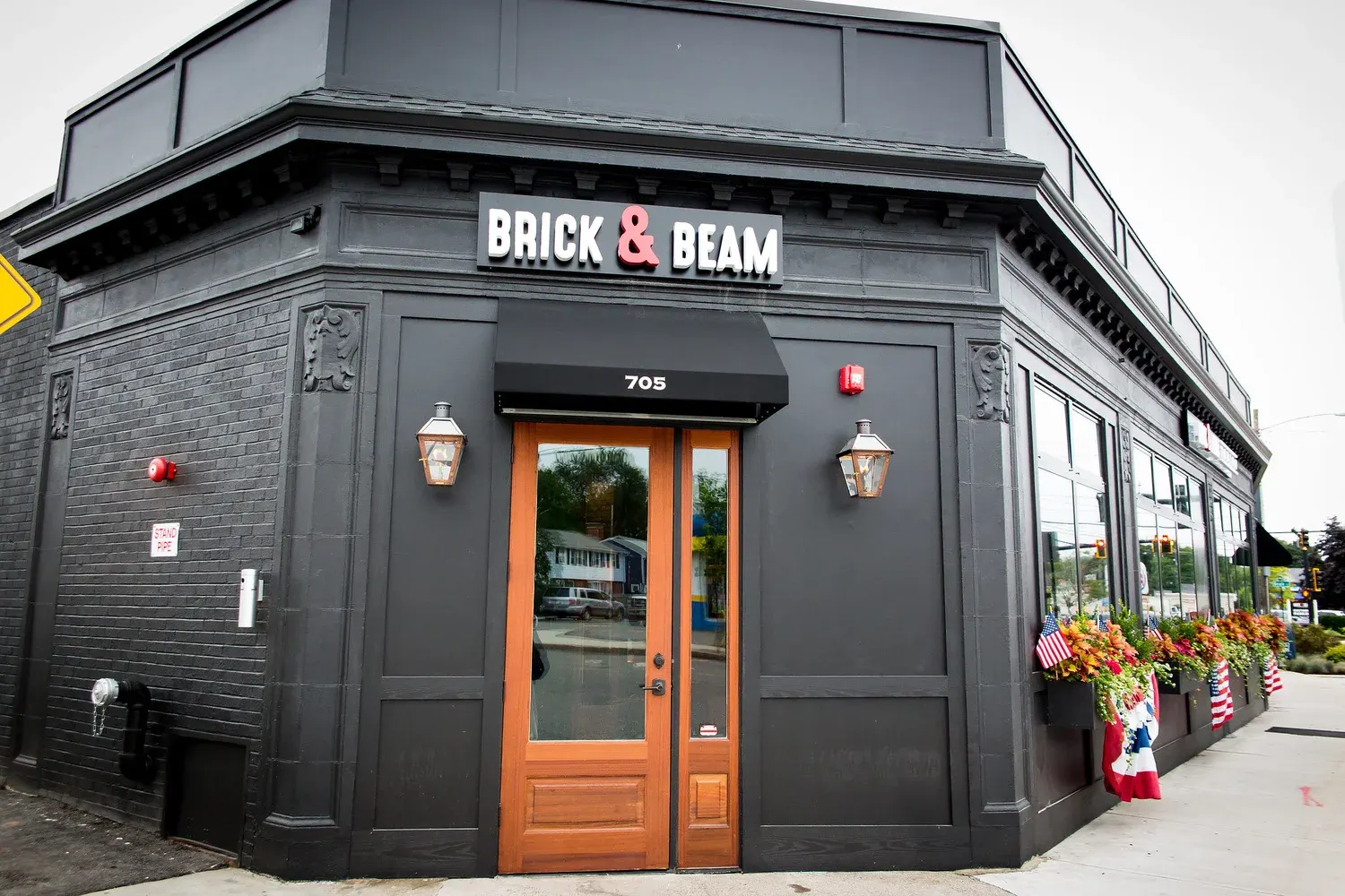 Brick & Beam Tavern storefront at 705 Adams Street, Quincy, with its orange door and flower boxes