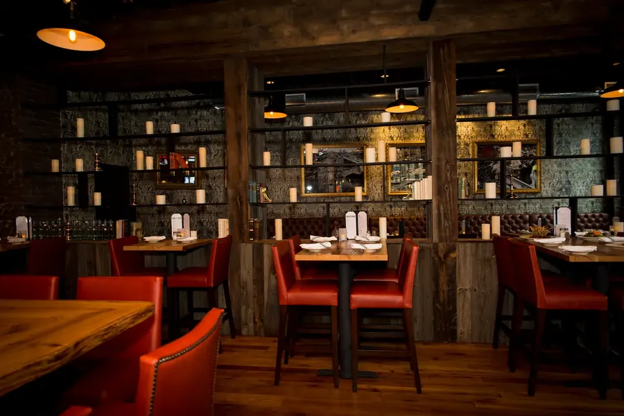 Dining room with red chairs and shelving at Brick & Beam Tavern