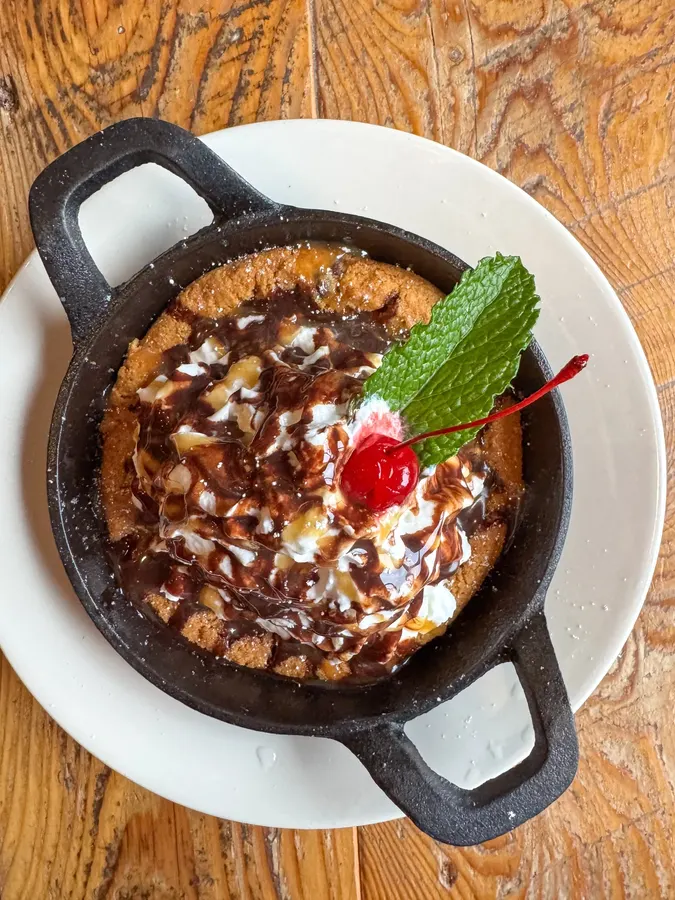 Skillet dessert topped with mint and a cherry